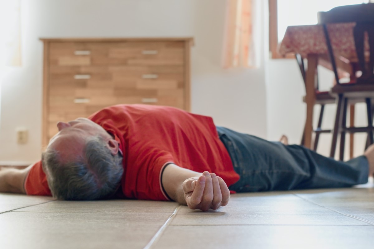 Un hombre inconsciente tendido en el suelo de una casa