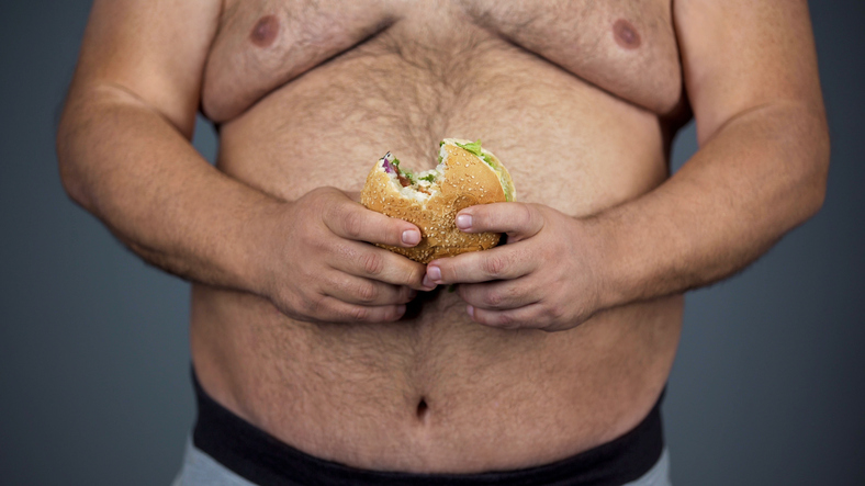 Un hombre, una gran barriga y una hamburguesa