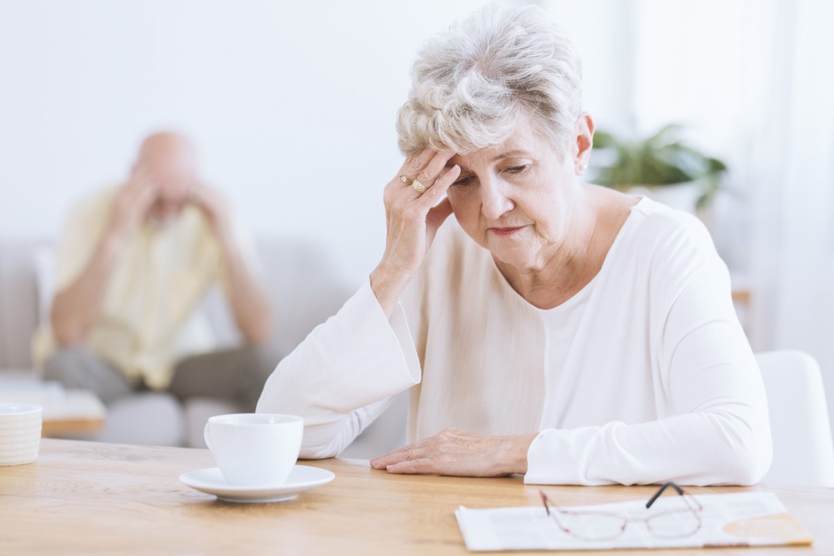 Anciana sujetándose la cabeza, debido al deterioro de las funciones neurológicas del cerebro, posible enfermedad de Alzheimer. Anciana en primer plano, con la cabeza inclinada, apoyada en la mano.