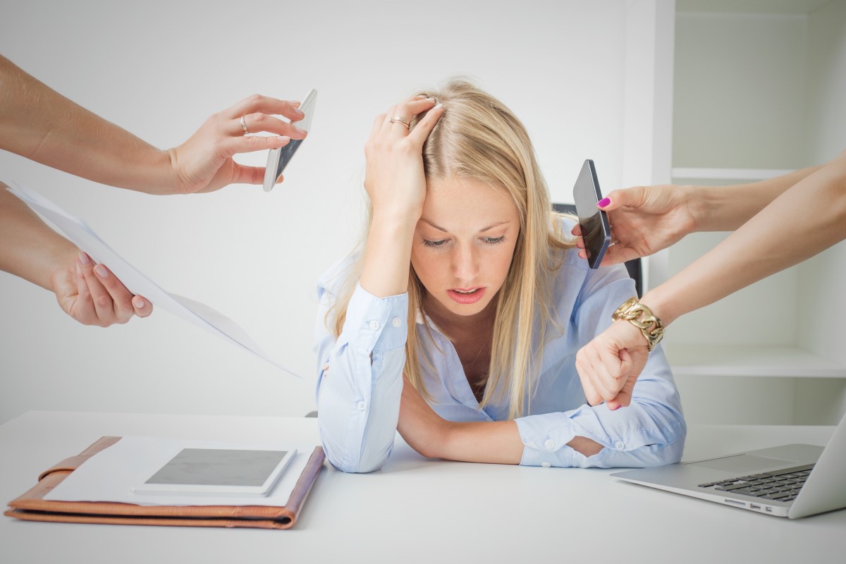 La mujer no está interesada en el trabajo, está agobiada, agotada, sentada en su mesa y sin trabajar.