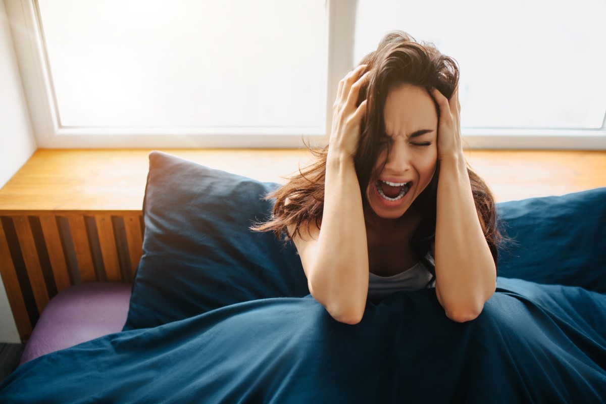 Mujer con fuerte dolor de cabeza, síntoma de hemorragia cerebral.