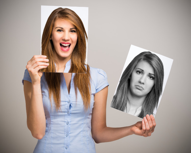 una mujer con dos fotografías, la primera sonriente y la segunda triste fuera de su cara