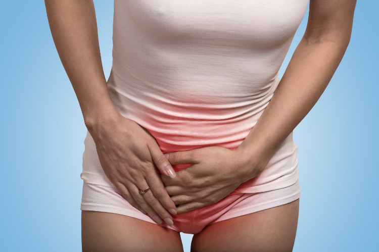 mujer sujetándose la zona abdominal inferior por dolor