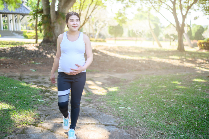 Mujer embarazada paseando por el parque.