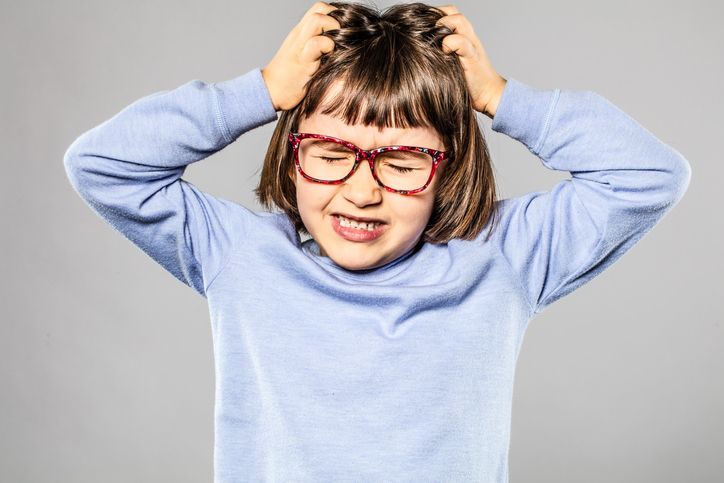 Niña nerviosa, rascándose la cabeza