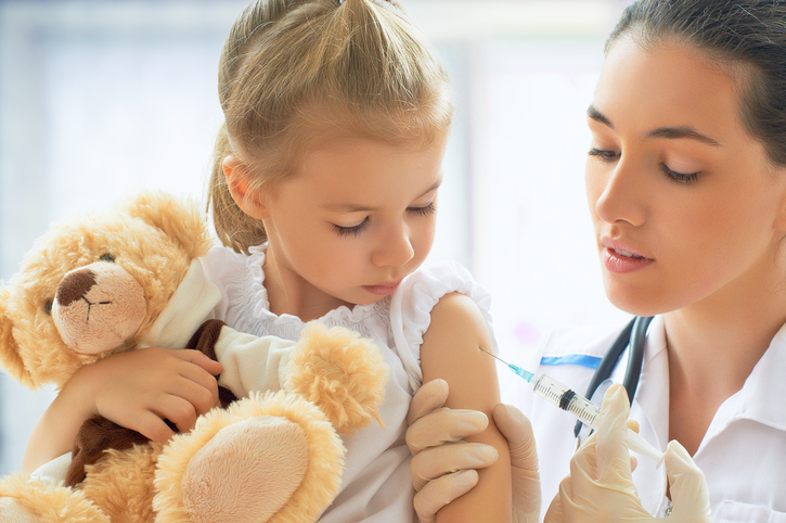 Vacunar a un niño con un peluche