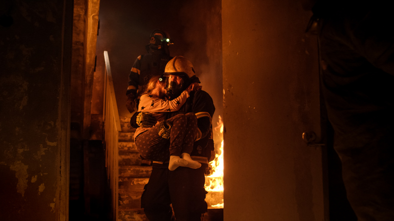 incendio en la casa, los bomberos sacan al niño en brazos