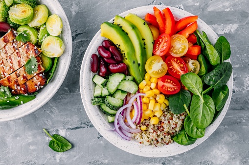 Platos llenos de comida con muchas verduras frescas.