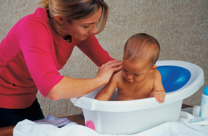 Madre bañando a su bebé en la bañera