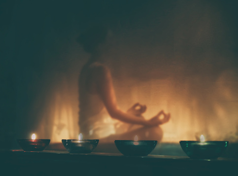 mujer meditando a la luz de las velas