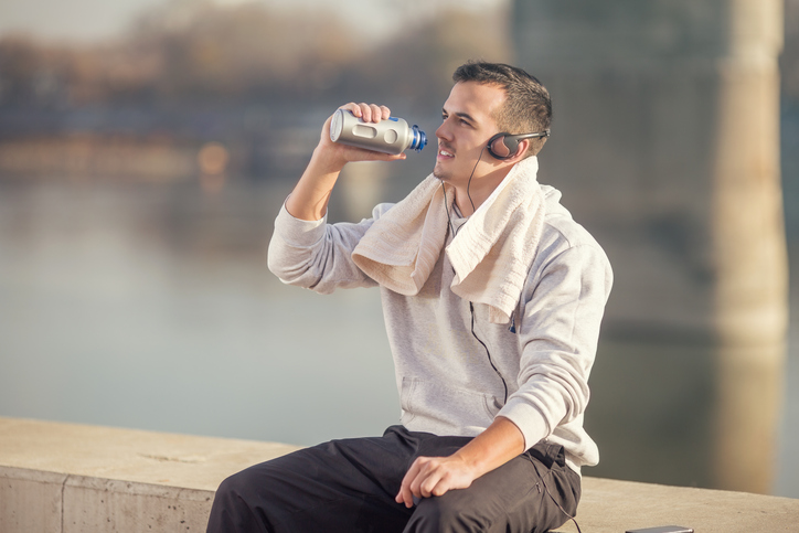 Un atleta bebe agua de una botella