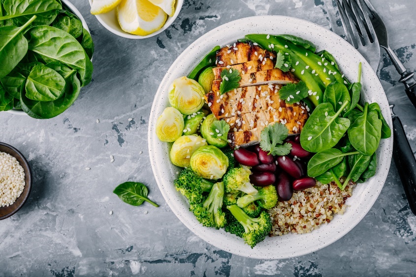 Ejemplo de comida principal completa: pollo magro y alubias (proteínas), muchas verduras (fibra y nutrientes), medio aguacate (grasa) y quinoa (carbohidratos complejos).