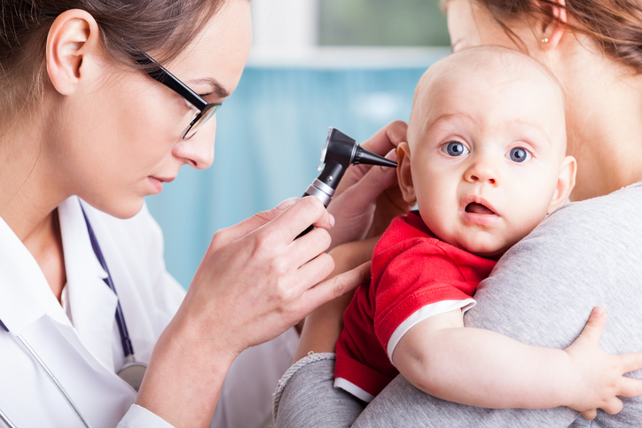 un médico examina el oído de un niño con una máquina