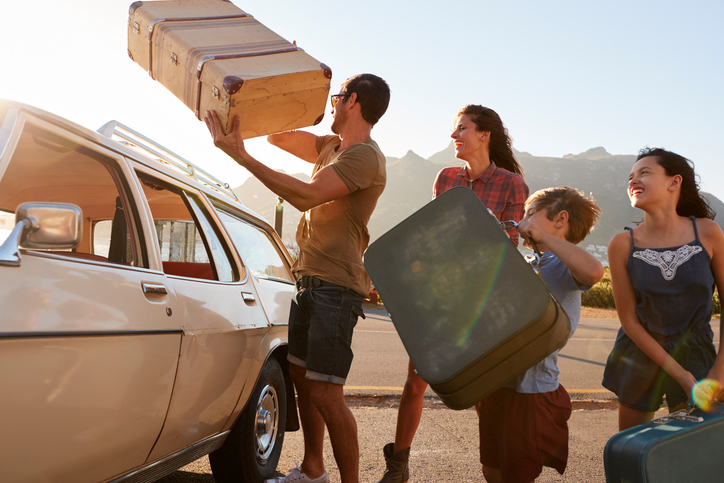 familia haciendo las maletas en el coche antes de las vacaciones