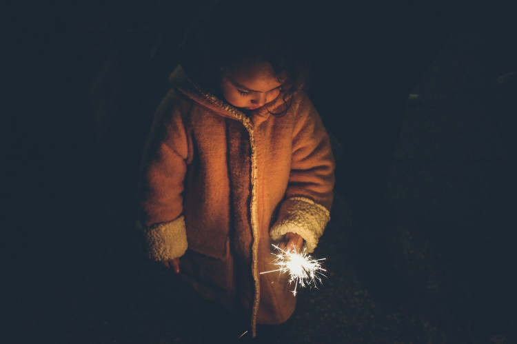 una niña con abrigo y una bengala en la mano mirando tristemente al suelo