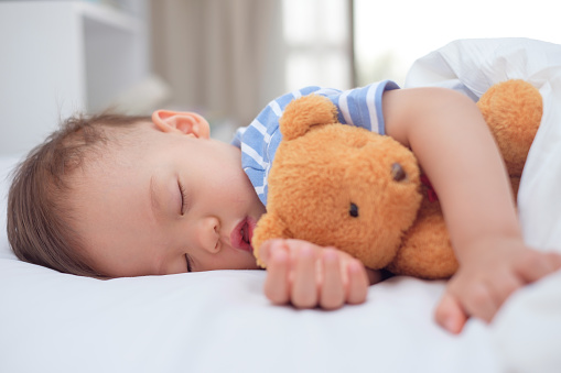 Niño durmiendo con su osito de peluche