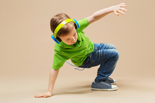 Un chico con camiseta verde y auriculares hace break dance