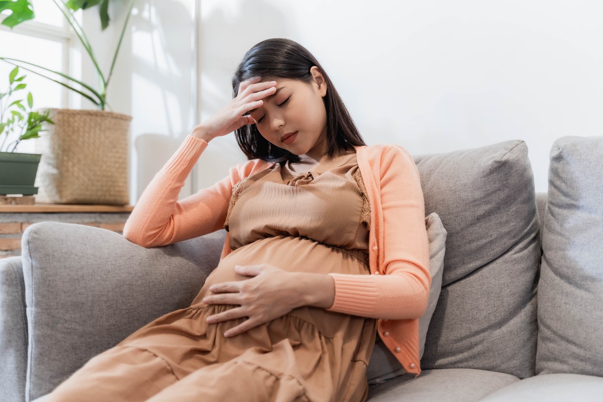 La mujer embarazada tiene dolores de cabeza