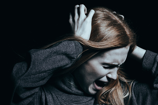 la mujer se agarra el pelo y grita, es agresiva