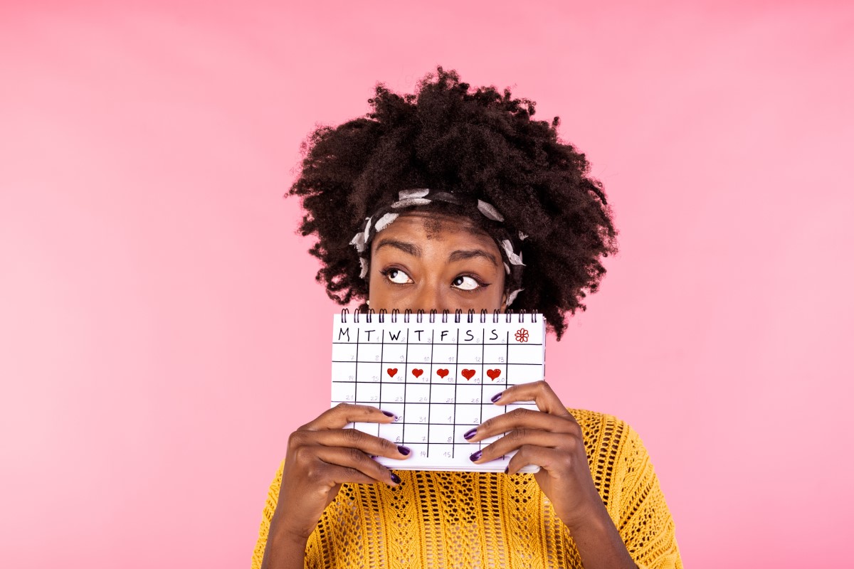 Mujer sosteniendo un calendario menstrual