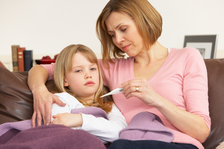 Una madre preocupada toma la temperatura a su hija