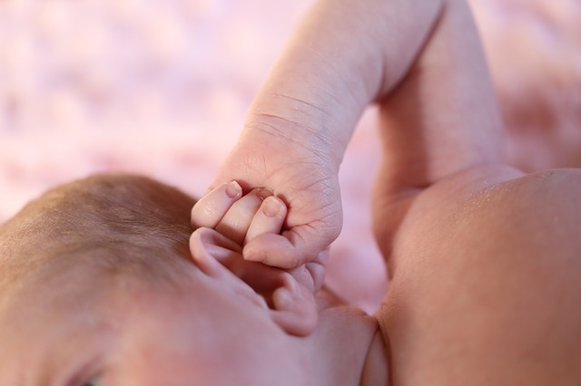 un niño pequeño se agarra la oreja con la mano