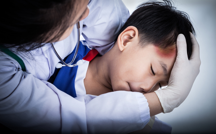 un niño tiene una herida en la cabeza, su frente está magullada, un médico lo está examinando