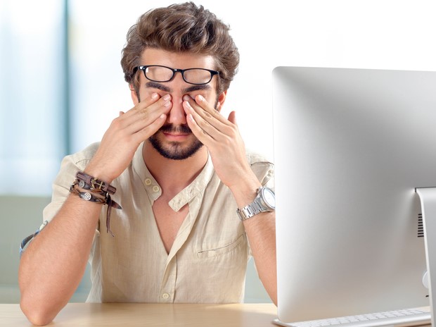 A un hombre le duelen los ojos, tiene el síndrome del ojo seco por trabajar mucho tiempo delante del ordenador