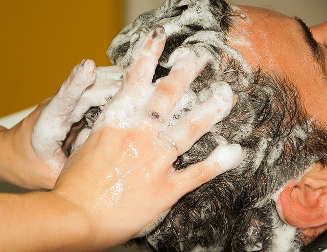 los hombres se lavan el pelo y se lavan la cabeza con champú, las manos en el pelo