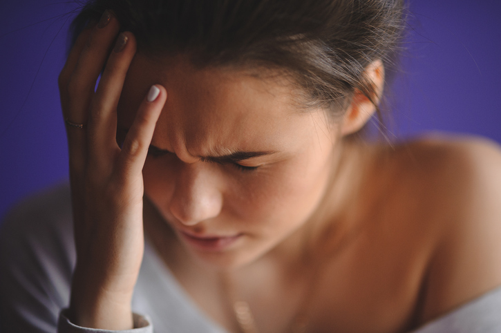 Mujer se agarra la cabeza, le duele la cabeza