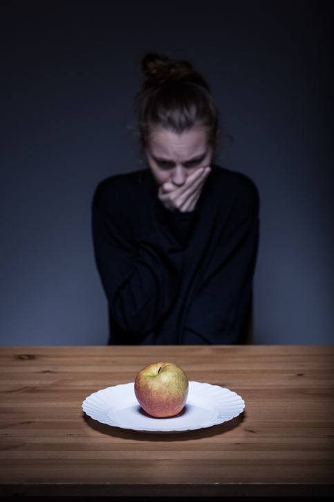 Mujer rechaza la comida, hay una manzana en el plato, asqueroso