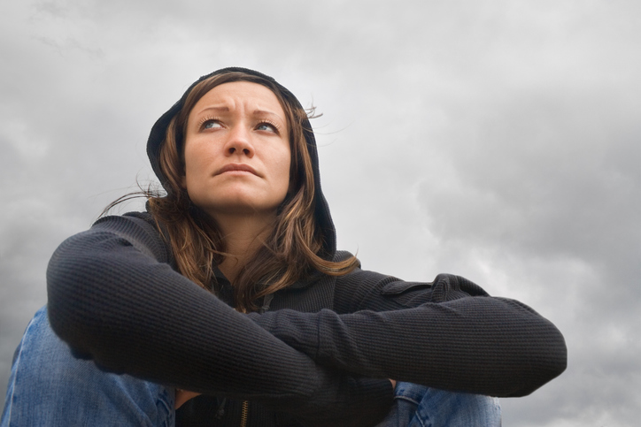 Mujer sentada, ánimo deprimido, tiempo nublado